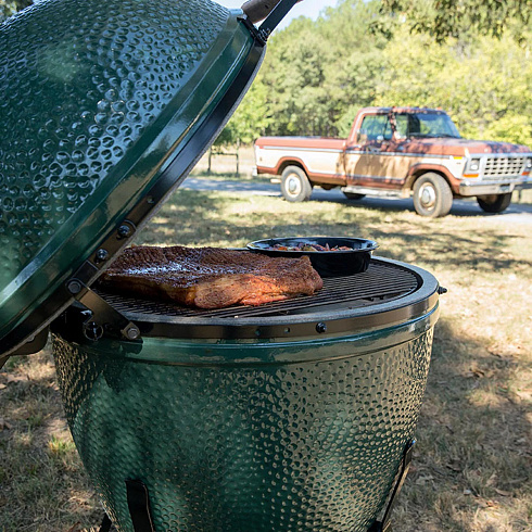 Красный керамический гриль камадо с открытой крышкой и горящими углями